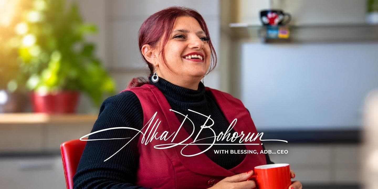 A woman smiling while holding a red cup in a bright indoor setting