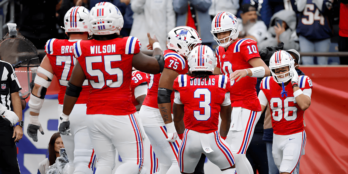 New England Patriots players celebrate a touchdown in their red home uniforms