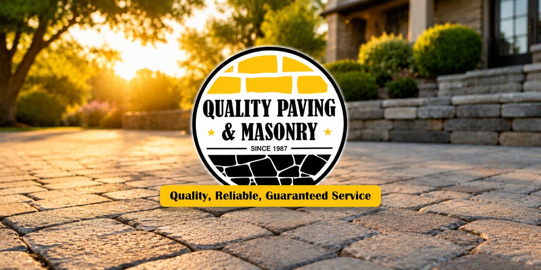 Quality Paving and Masonry logo over a stone driveway at sunset, showcasing professional paving and masonry services in New Jersey.