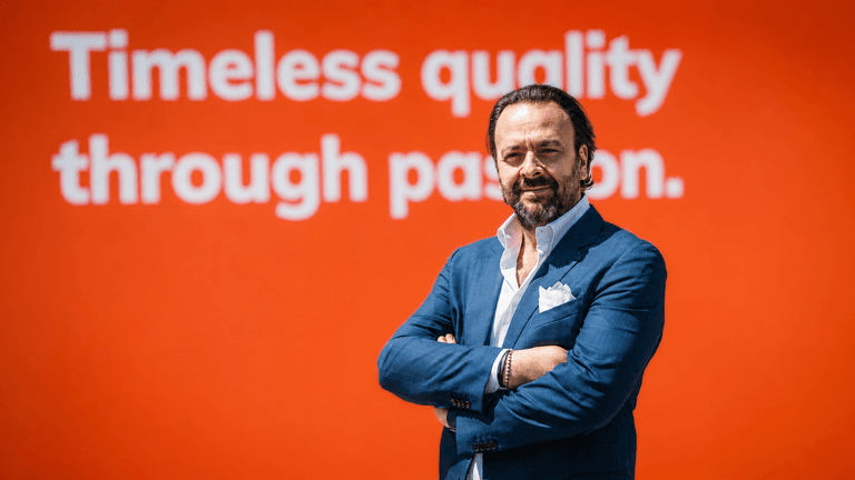 Umberto Maria Cini, Dulevo Sales & Marketing VP, standing before a corporate display.