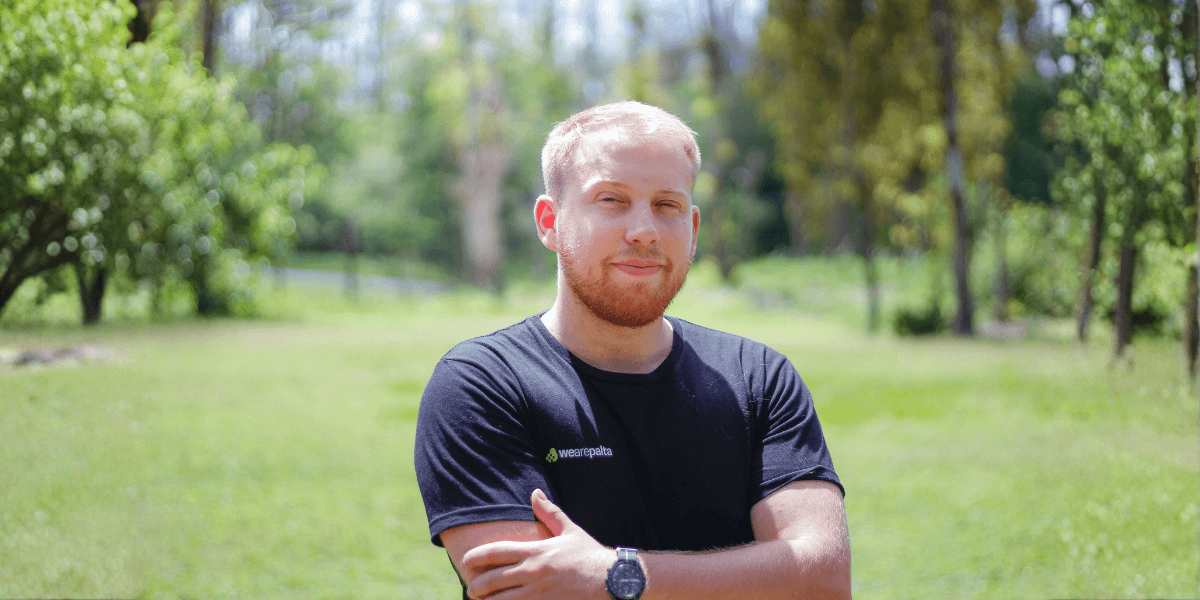 Augusto Boretti, founder of WeArePalta, stands confidently outdoors in front of a lush green background, symbolizing innovation.