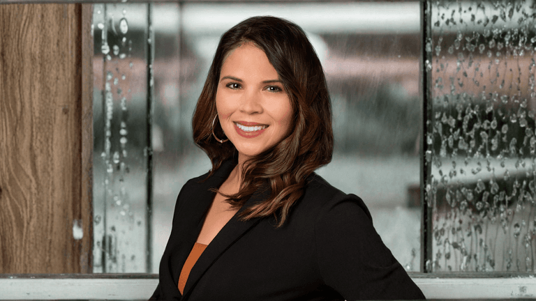 Melissa Crews, founder of Seize the Moment Wellness Coaching, smiling with a rain-covered window backdrop.