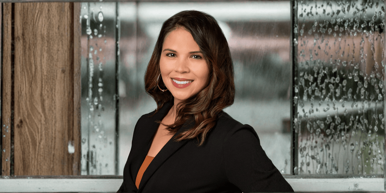 Melissa Crews, founder of Seize the Moment Wellness Coaching, smiling with a rain-covered window backdrop.