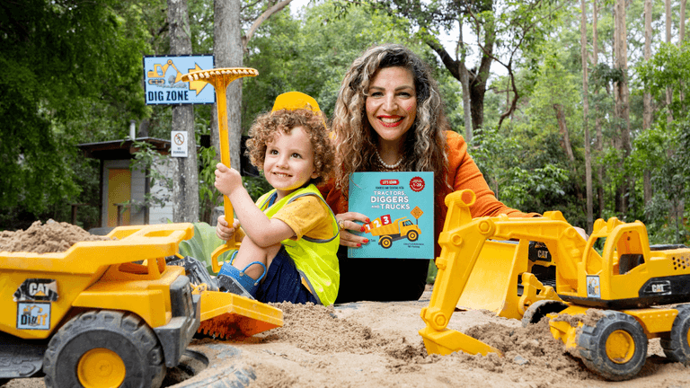 Ghina reading with children, pointing to a page from her educational book "Let’s Learn Numbers."