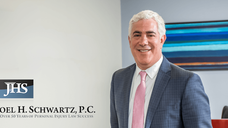 “Professional attorney in suit standing beside Joel H. Schwartz, P.C. branding, representing the firm’s personal injury expertise and client-focused legal services.”
