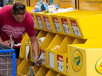A woman shopping for school supplies at a Crayola display in a store