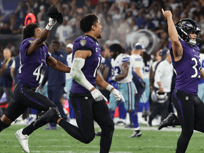 Ravens players celebrate a victory on the field during a football game