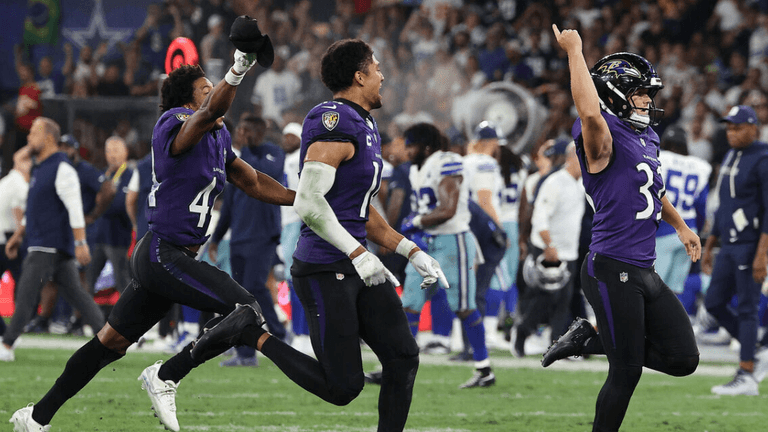 Ravens players celebrate a victory on the field during a football game