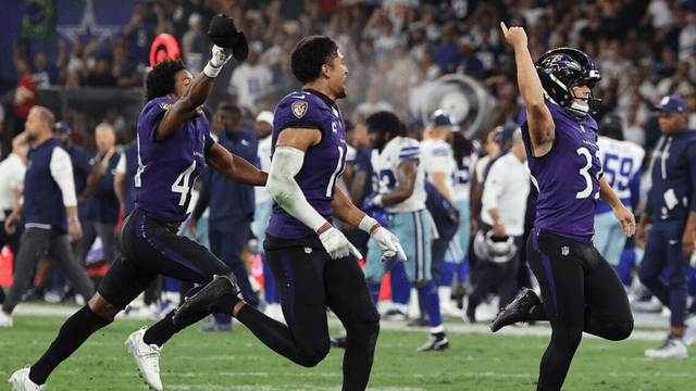 Ravens players celebrate a victory on the field during a football game
