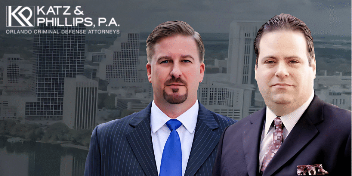 Two suited men in front of a city skyline with the Katz & Phillips, P.A. logo above them.