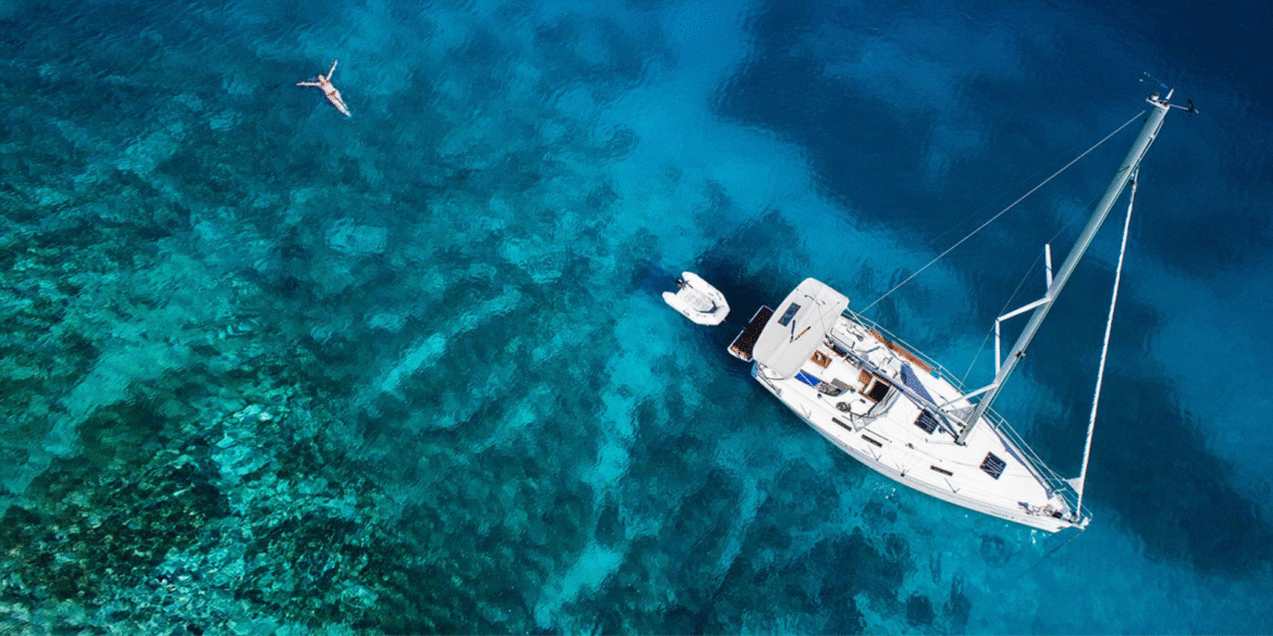 Aerial view of a yacht and crystal-clear water, representing Go Sail Greece's luxurious, personalized sailing experiences across stunning Greek islands.