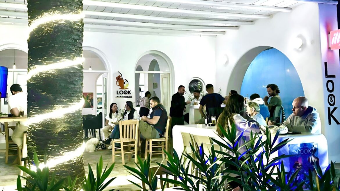 "Interior of Look Cafe & Billiards Bar in Drios, Paros, with people enjoying food and drinks in a lively atmosphere."