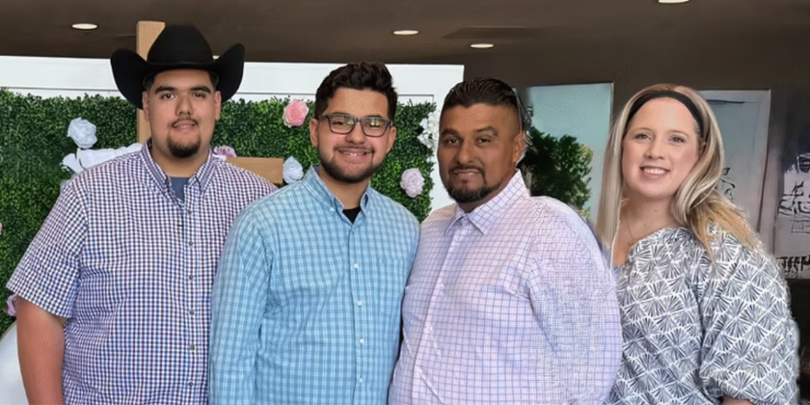 "A family of four smiling together, dressed in plaid shirts, with a floral background reflecting a warm, supportive atmosphere."