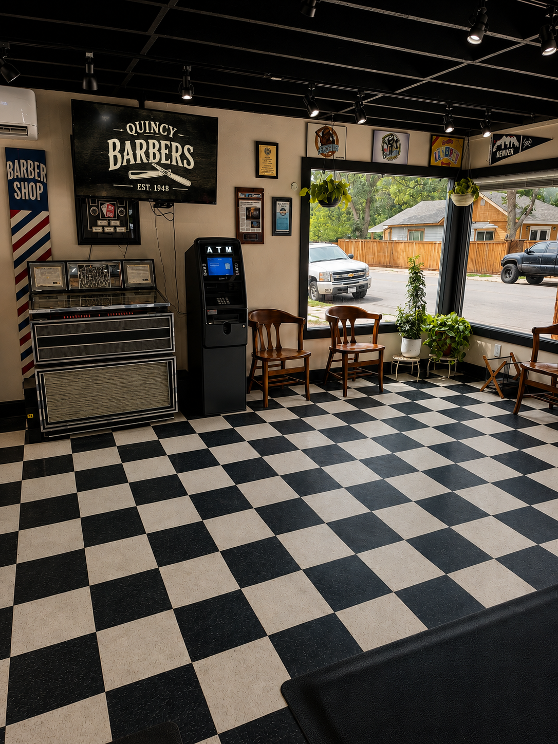 Quincy Barbers waiting area with checkered floor, seating, and vintage barbershop décor.