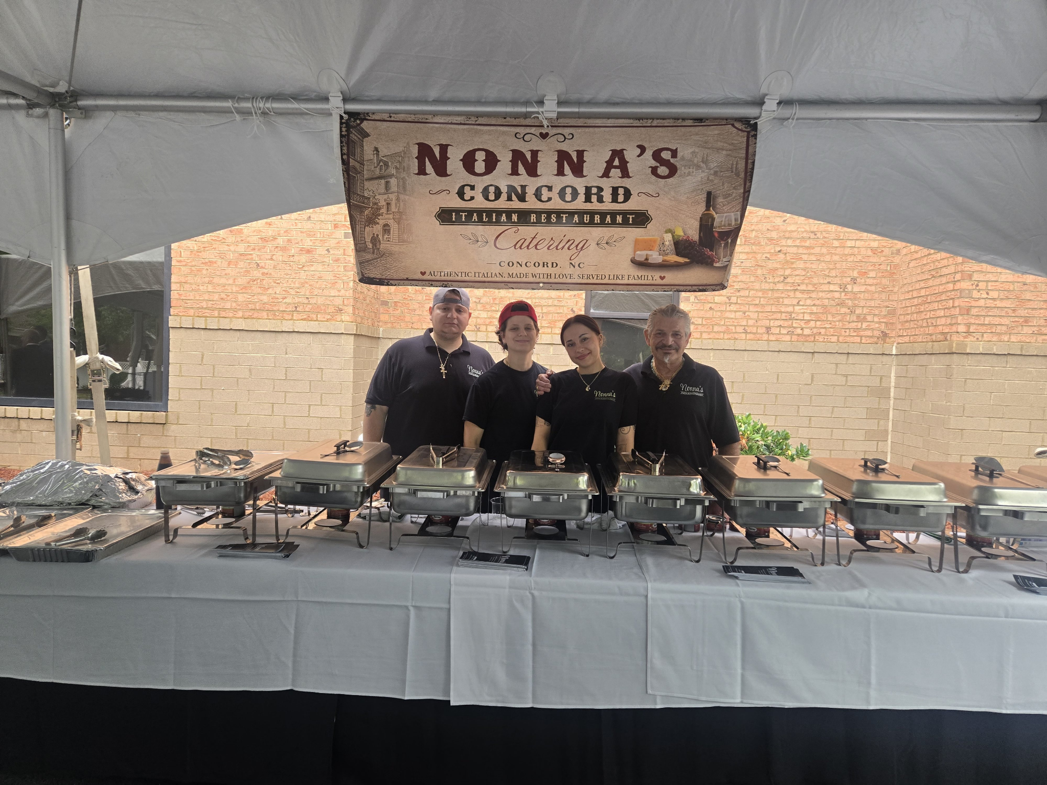 Nonna's Italian Restaurant catering team behind buffet setup at an event in Concord, North Carolina.